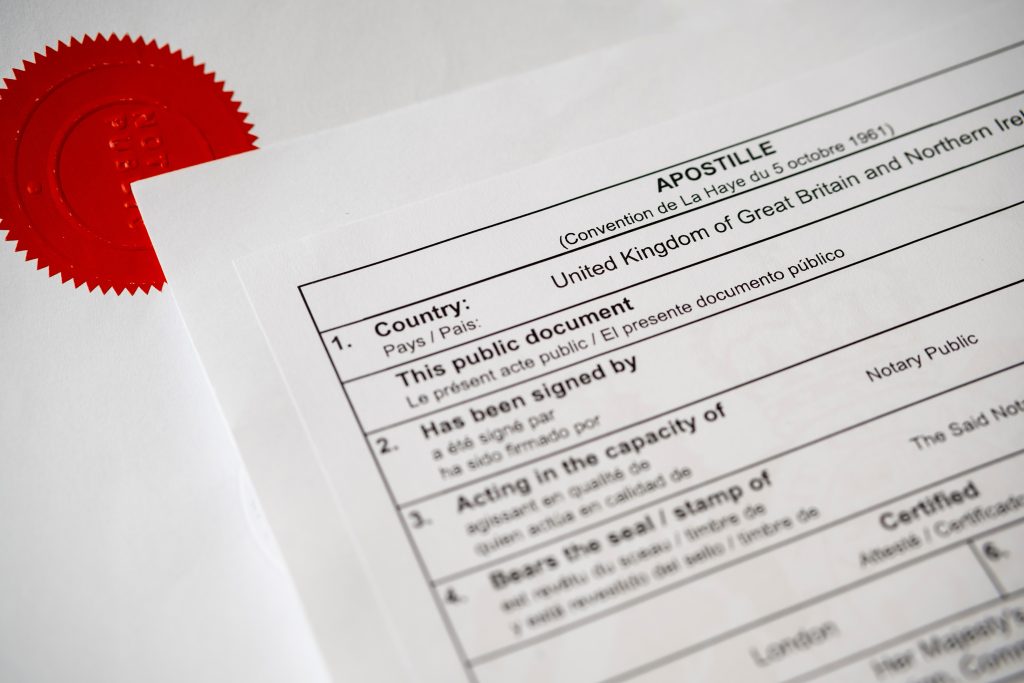 authentic apostille certificate document. the red stamp "notary public" on official document seen on the blurred background. real documents.